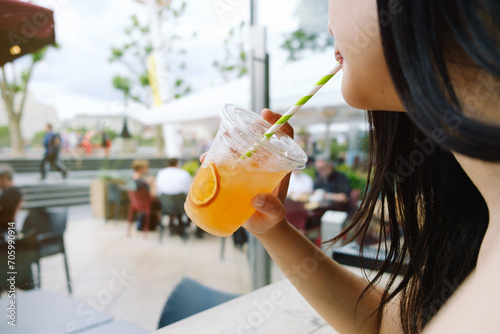 A woman drinking juice on a terrace