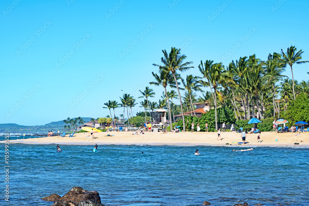 Vacationers and locals enjoy the beautiful Poipu Beach on the island of Kauai, Hawaii.