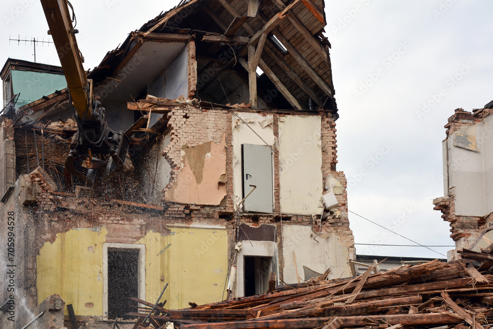 Dismantling a building on a city street with an excavator. Reconstruction and renovation of cities