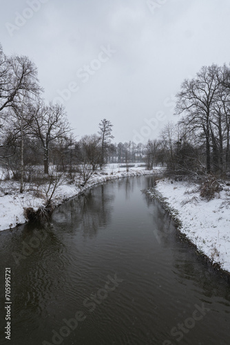 Zimowa panorama rzeki Osobłogi w popołudniowych godzinach pochmurnego szarego dnia w Zachodniej Polsce © FIOMI