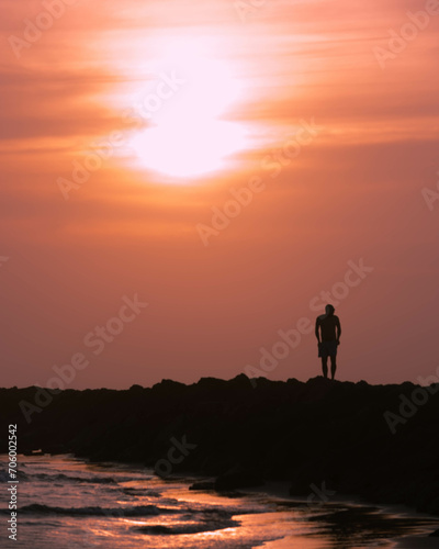 people in silhouette on the beach next to the sea with sunset. Cartagena Colombia.
