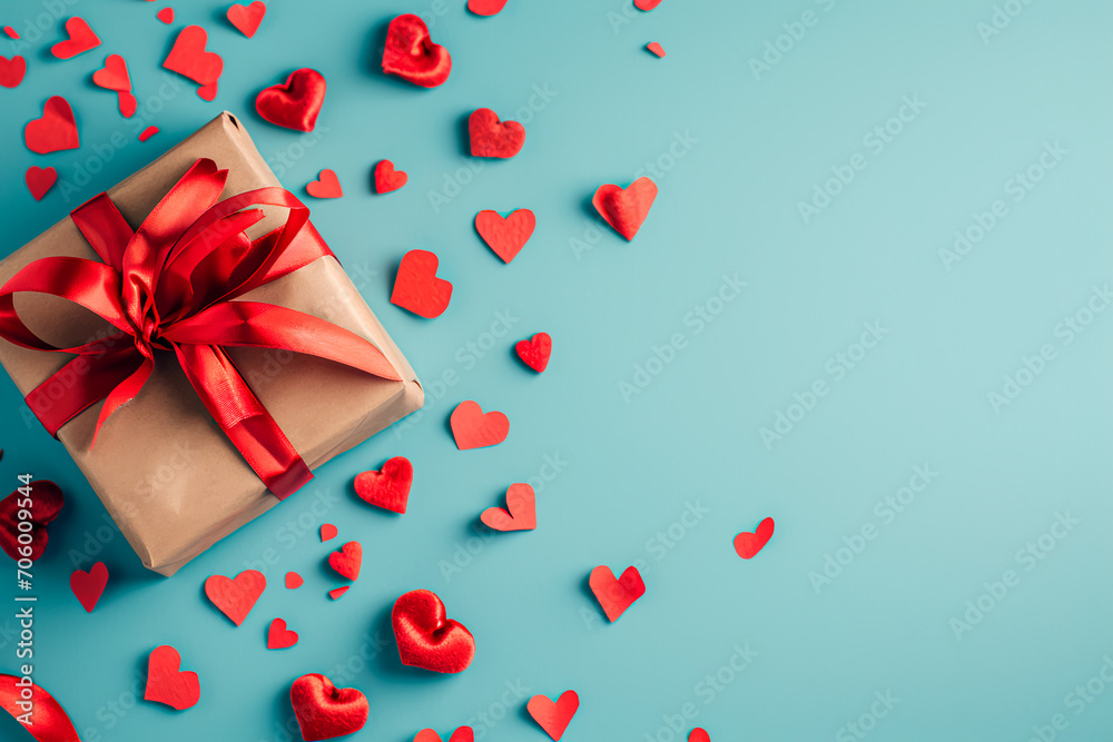 Top view of a Valentine's or Mother's Day festive composition featuring gift boxes and red hearts on a pastel blue background. This flat lay creates an ideal greeting card.