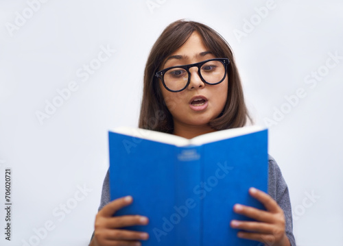 Child, book and reading for development in education, information and knowledge by white background. Girl, student and learning or studying in studio, academy and notebook for story and growth