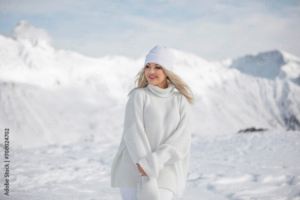 Beautiful blonde girl in the mountains of the Swiss Alps. Winter sunny day, a lot of snow. Resort Beautiful blonde girl in the mountains of the Swiss Alps. Winter sunny day, a lot of snow. Resort
