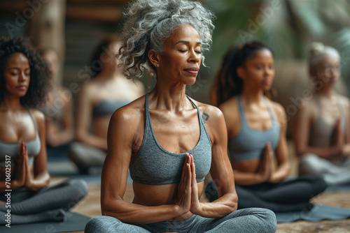 Diverse group of senior women meditating together in yoga class