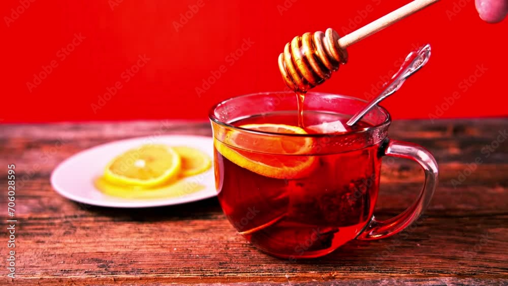 Adding honey to tea with wooden honey spoon Adding honey to tea with wooden honey spoon