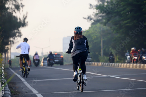 rear view of man cycling in the morning with morning sunlight. cycling to maintain fitness and a healthy lifestyle.