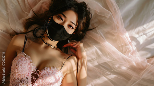 Cute Asian girl in mask lies on bed photo