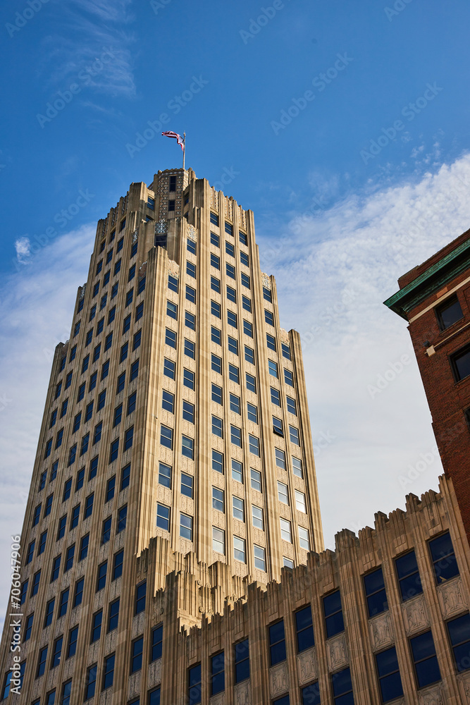 Fototapeta premium Art Deco Skyscraper with American Flag, Clear Blue Sky Perspective