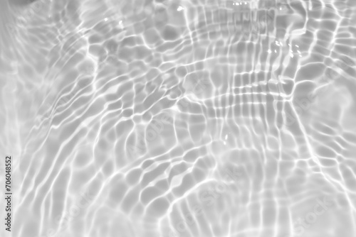 White water with ripples on the surface. Defocus blurred transparent white colored clear calm water surface texture with splashes and bubbles. Water waves with shining pattern texture background.