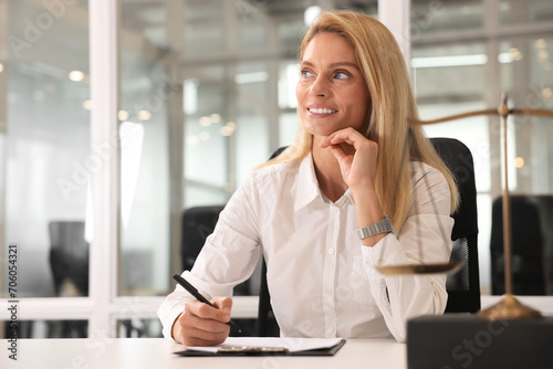 Smiling lawyer working at table in office, space for text