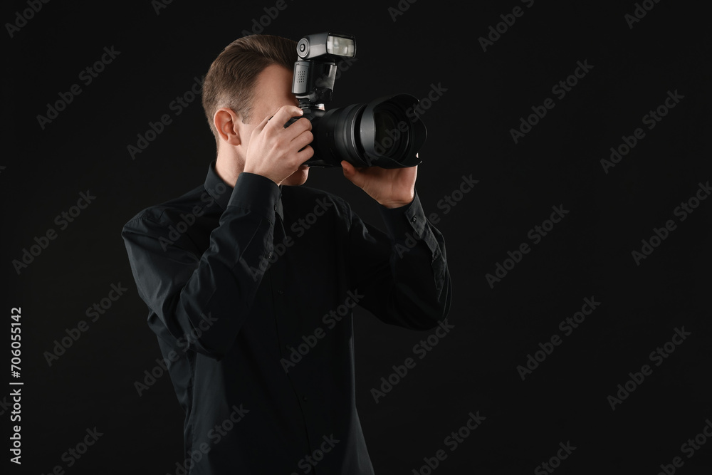 Professional photographer taking picture on black background, space for text Professional photographer taking picture on black background, space for text