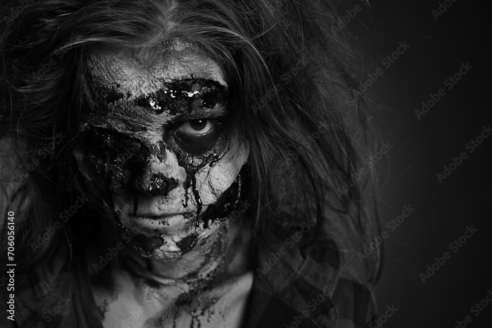 Scary zombie on dark background, black and white effect. Halloween monster