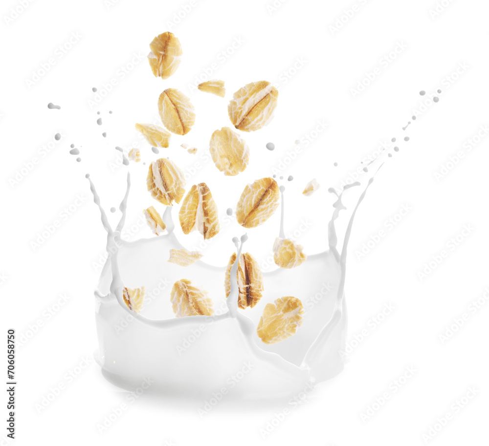 Rolled oats falling into splashing milk on white background