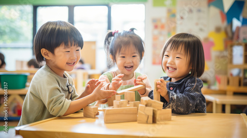 Obraz na płótnie 日本の幼稚園児3人が私服で木の積み木を使って笑顔で遊んでいる写真、背景保育ルーム、木育/幼児教育 w salonie