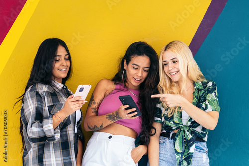 Girls using smartphone outdoors. Colorful background