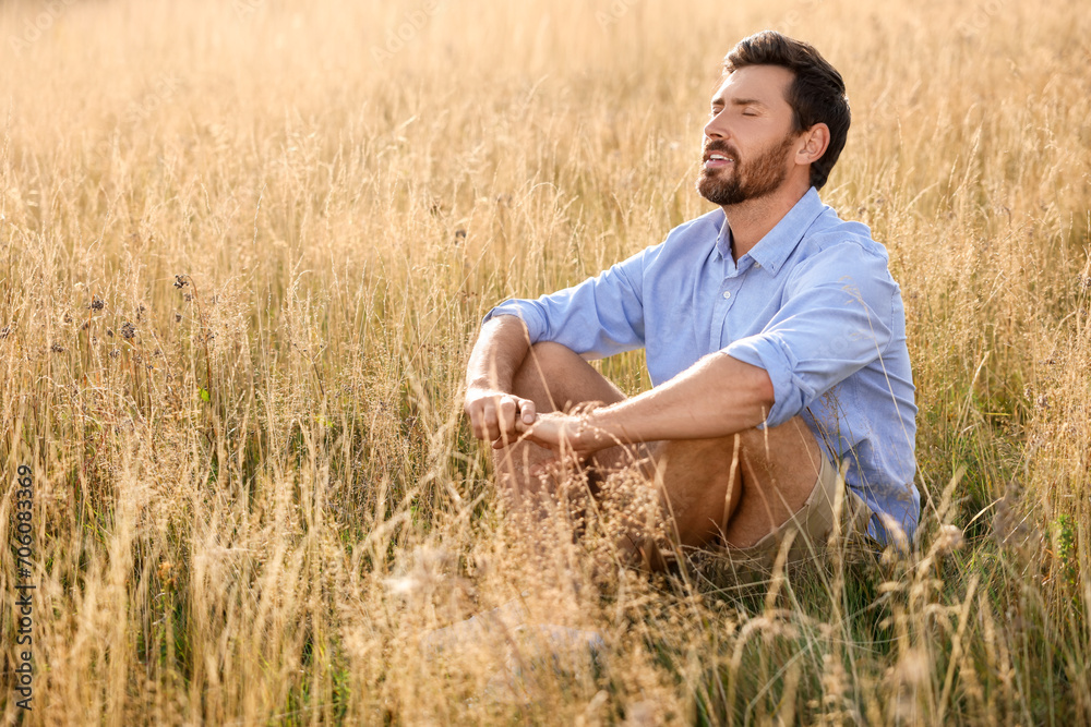 Man enjoying feeling of freedom on reed grass meadow Man enjoying feeling of freedom on reed grass meadow