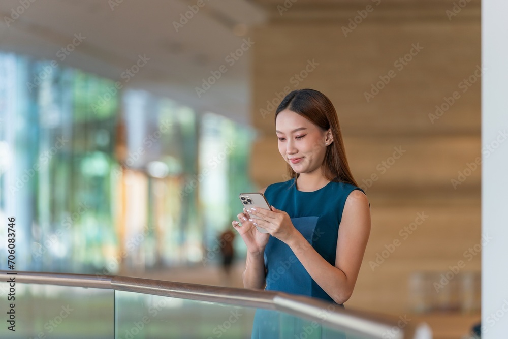 Asian Businesswoman Using Phone in a Modern Office Building in Downtown Asian Businesswoman Using Phone in a Modern Office Building in Downtown