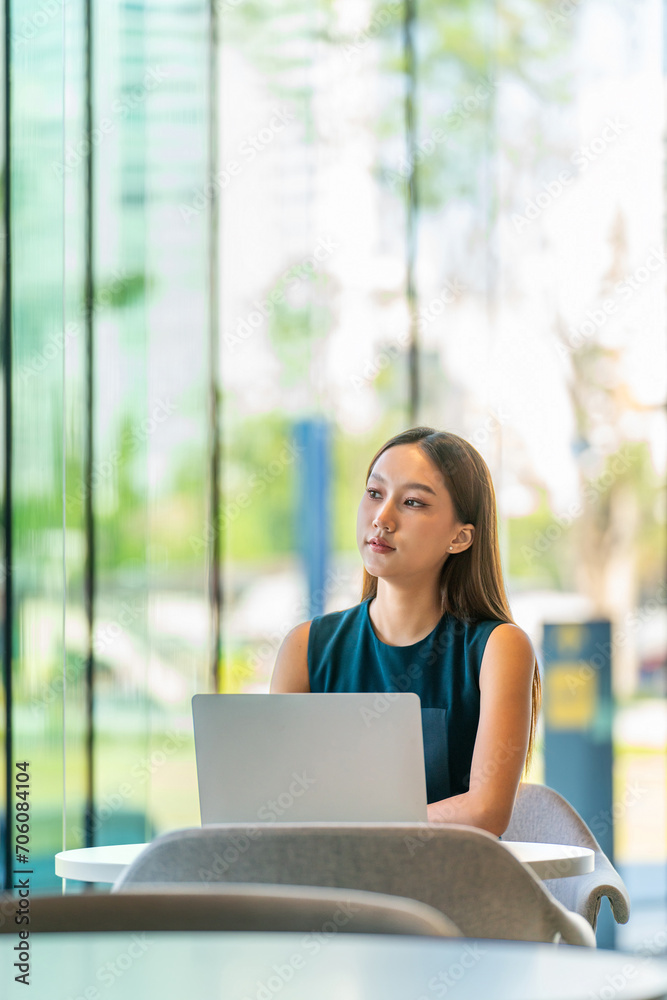 Portrait of an Asian Business Woman Working on a Laptop with a Elegant Look and Smile Outside the Office Portrait of an Asian Business Woman Working on a Laptop with a Elegant Look and Smile Outside the Office