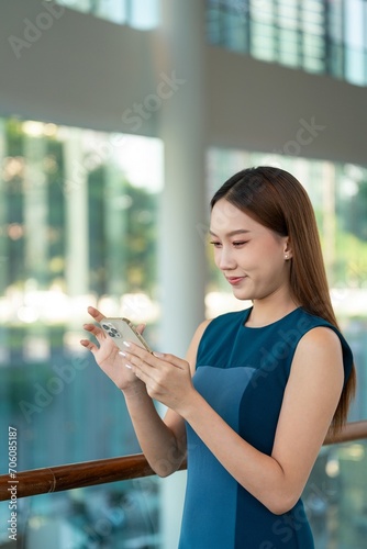 Asian Businesswoman Using Phone in a Modern Office Building in Downtown