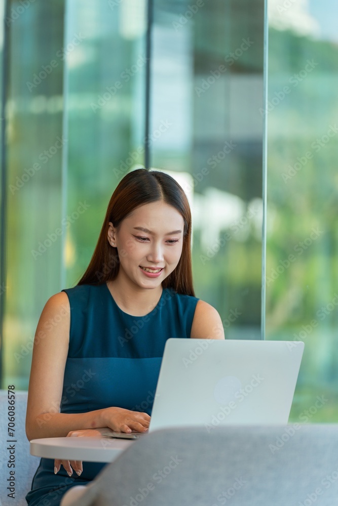 Young asian businesswoman working on laptop at a shared workplace out of the office Young asian businesswoman working on laptop at a shared workplace out of the office