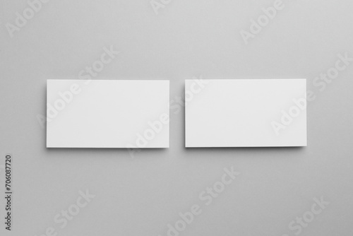 Blank business cards on light gray background, top view. Mockup for design