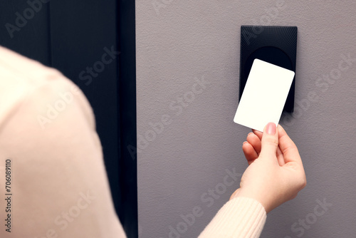 Woman opening magnetic door lock with key card, closeup. Home security photo