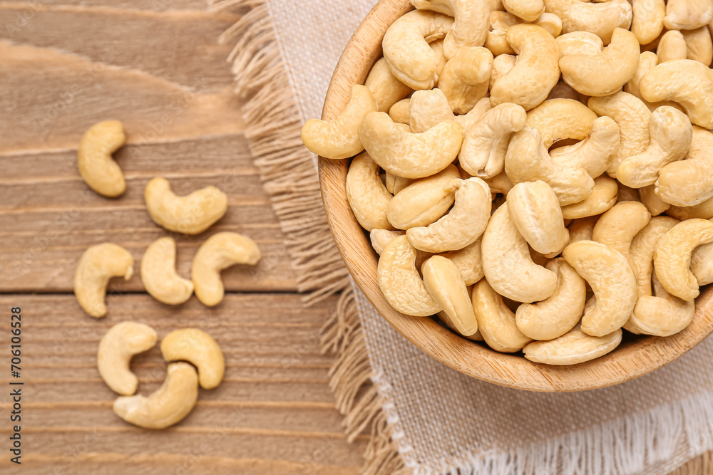 Bowl with tasty cashew nuts on wooden background Bowl with tasty cashew nuts on wooden background