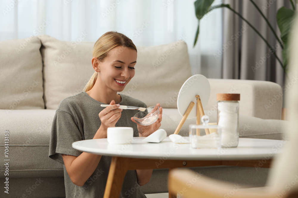 Young woman preparing face mask in front of mirror at home. Spa treatments Young woman preparing face mask in front of mirror at home. Spa treatments