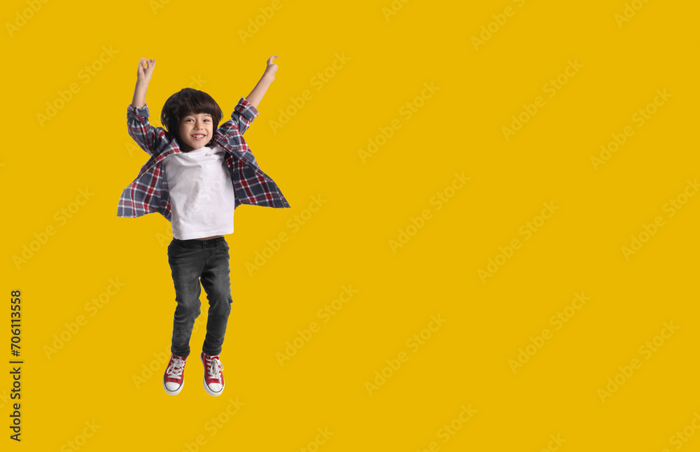 Happy boy jumping on golden background, space for text Happy boy jumping on golden background, space for text
