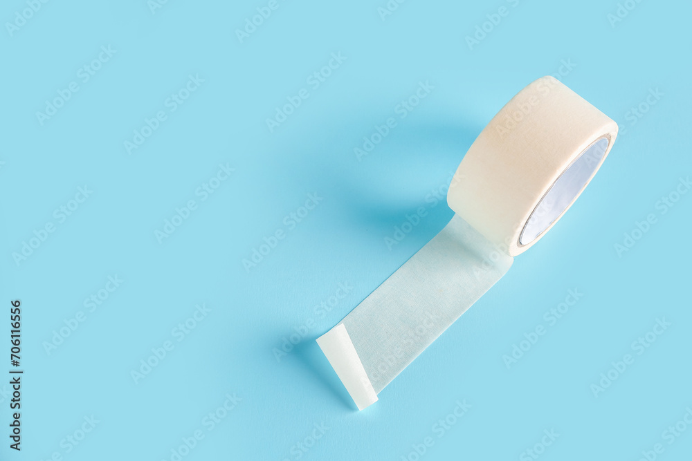 Adhesive tape roll on blue background Adhesive tape roll on blue background