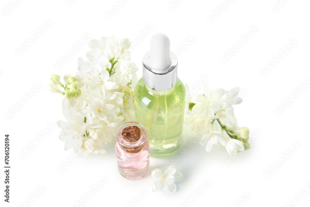 Bottles of cosmetic oil with beautiful lilac flowers on white background Bottles of cosmetic oil with beautiful lilac flowers on white background