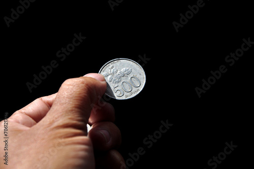 Holding indonesian coin money black background