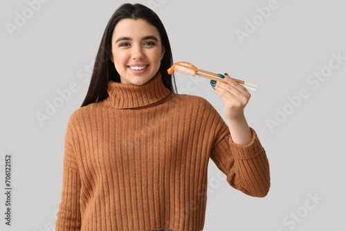 Young woman with sushi on l...