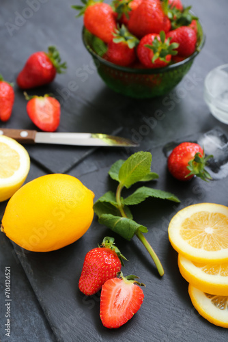 Fototapeta Naklejka Na Ścianę i Meble -  Ripe strawberry, lemon and mint on dark background, closeup