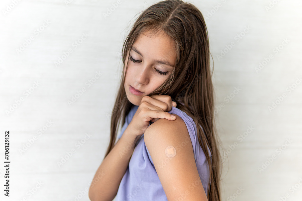 little girl showing her arm with bandage after virus vaccine. Kid and child vaccination campaign. Protect your kid with vaccine concept little girl showing her arm with bandage after virus vaccine. Kid and child vaccination campaign. Protect your kid with vaccine concept