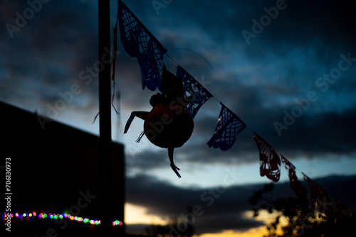 Artesania Mexicana. Pequeña piñata a contraluz colgada en una cuerda con papel picado al atardecer. photo