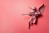 Sculpture of angel with gun in hands on pastel pink background. Cupid angel statue with rifle. Copy space for text. For banner, card. concept of love and Valentine's day