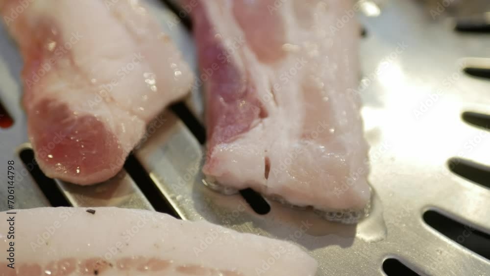 selective focus view to the pork meat while being grilled on the traditional korean charcoal pan stove called Galbi. selective focus view to the pork meat while being grilled on the traditional korean charcoal pan stove called Galbi.