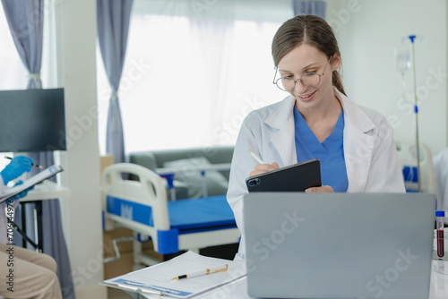 Portrait of a beautiful young female doctor sitting at a table Work in a medical clinic, in a resident's office at a computer