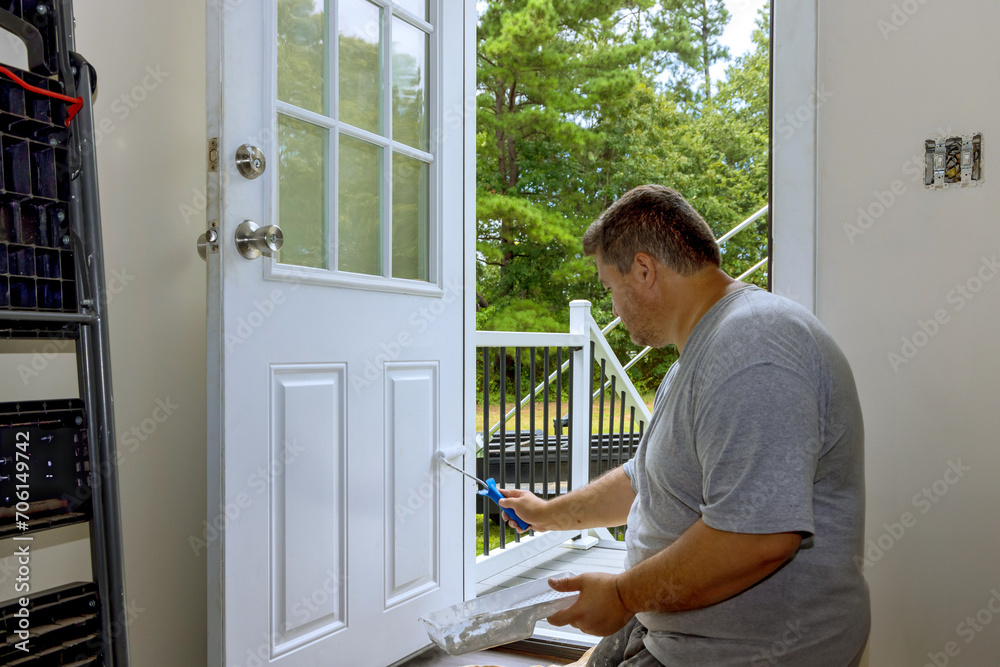 In process of renovating home, worker painted front door with paintbrush