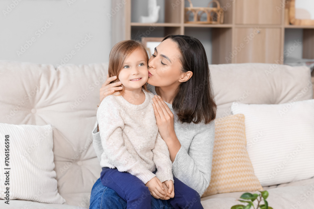 Beautiful mother kissing her cute little daughter at home Beautiful mother kissing her cute little daughter at home