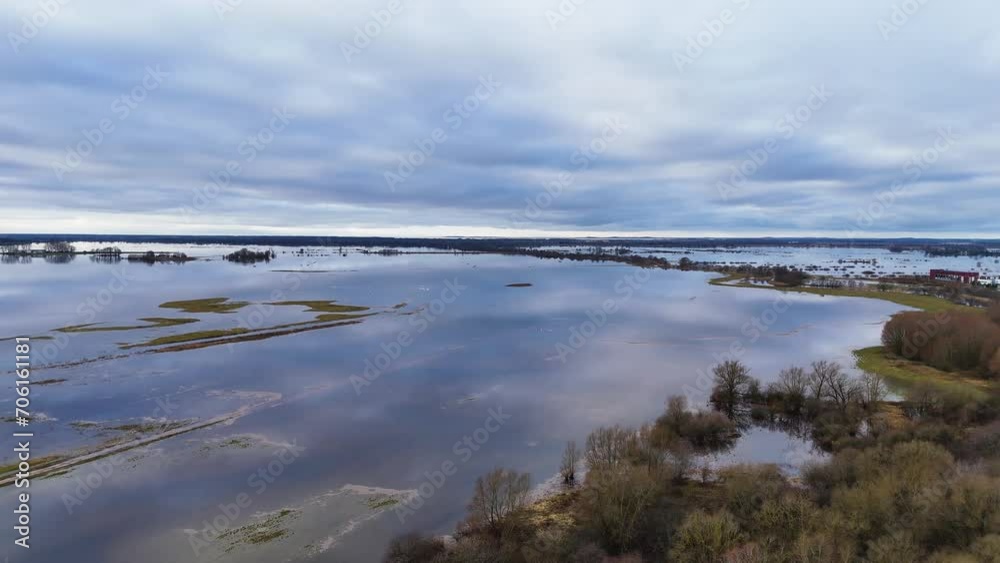 Aerial establish of flooded grass plains and leafless trees, water reflects cloudy sky Aerial establish of flooded grass plains and leafless trees, water reflects cloudy sky
