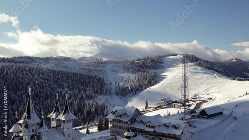 Church amidst snowy mountain peaks, aerial perspective. Romania, Rodna Mountains. photo