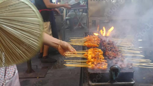 A man cooking BBQ items in a Malaysian food street