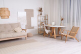 Blurred view of stylish living room with paintings, sofa and workplace