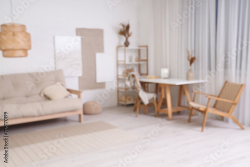 Blurred view of stylish living room with paintings, sofa and workplace © Pixel-Shot