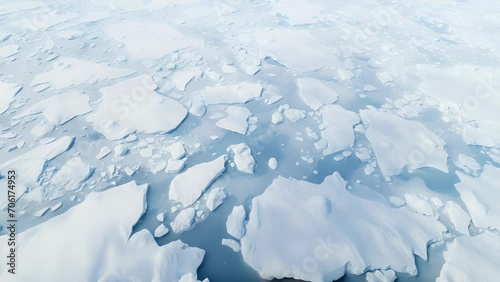 The once pristine white landscape is now a chaotic mix of freeting ice and murky waters, captured in stunning detail from an aerial perspective. photo