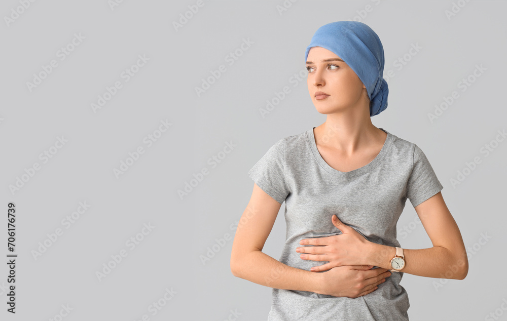 Young woman after chemotherapy suffering from pain on light background. Stomach cancer concept Young woman after chemotherapy suffering from pain on light background. Stomach cancer concept