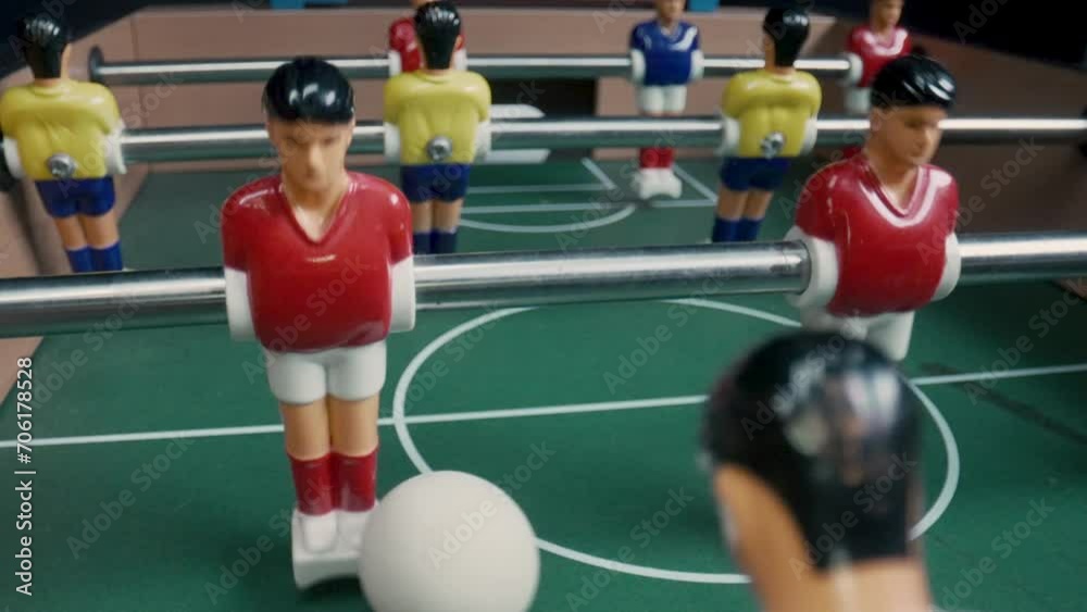 Foosball table players contending for the ball Foosball table players contending for the ball